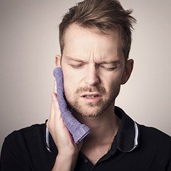 man holding jaw with dental emergency