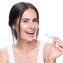 Smiling woman with Invisalign tray