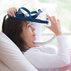Woman placing CPAP mask