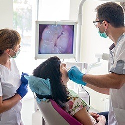 Dental team and patient looking at intraoral images