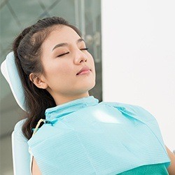 Relaxed woman with eyes closed in dental chair