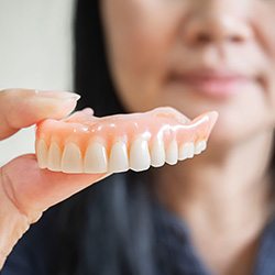 woman in the background holding her upper denture