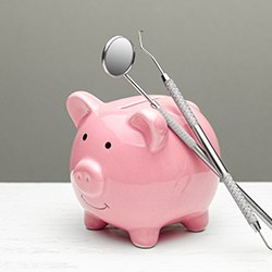 piggy bank with dental instruments showing the cost of dentures in Westhampton 