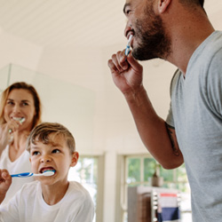 family brushing their teeth together at home 