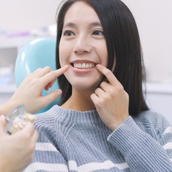 woman pointing to her teeth needing treatment