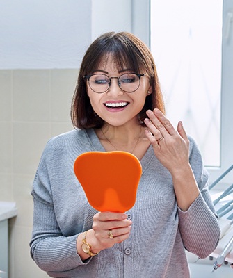 happy dental patient looking in a mirror