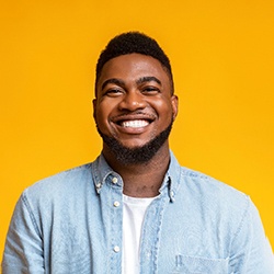 smiling man in front of a yellow background