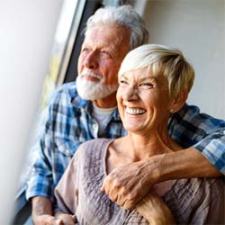 couple smiling and enjoy their new dental implants in Westhampton