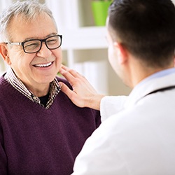 Smiling patient and dentist discuss the cost of dental implants in Westhampton