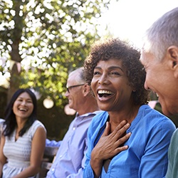 Smiling group of friends with dental implants in Westhampton laughing outside