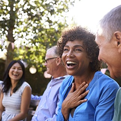 Smiling group of friends with dental implants in Westhampton laughing outside 