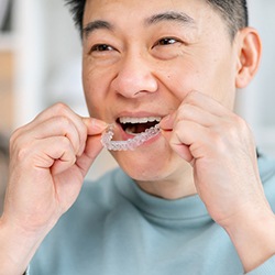 man putting in Invisalign after brushing teeth