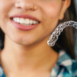woman holding an Invisalign tray