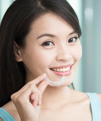 Woman placing Invisalign tray