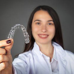 Woman holding up Invisalign