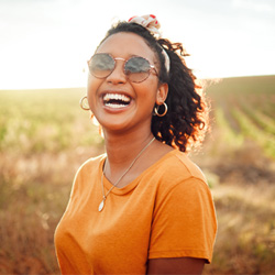 woman smiling and laughing outside in a field