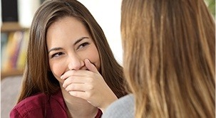 Woman covering her mouth as she smiles