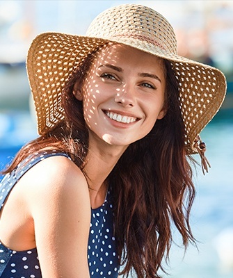 Smiling woman wearing large beach hat