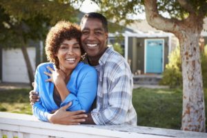 older couple smiling with dental implants in Westhampton