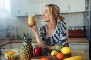 woman smiling and doing a juice cleanse showing diet trends
