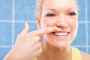 woman pointing at her healthy smile