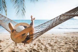 woman in a hammock on the beach enjoying her vacation