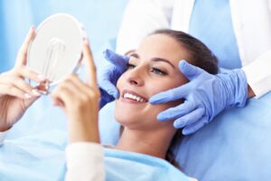 smiling patient looking in the mirror at the dentist’s office