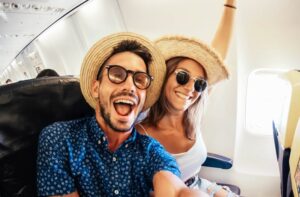 happy travelers taking a selfie on a plane