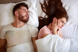 man snoring and annoying his partner