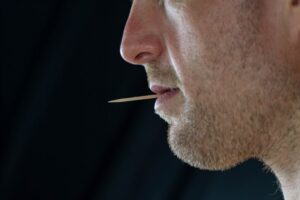 man holding a toothpick in his mouth
