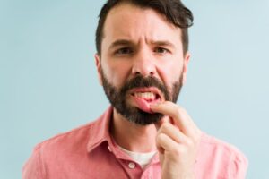 concerned man looking at his gums
